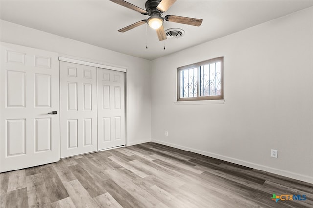 unfurnished bedroom with ceiling fan, a closet, and light hardwood / wood-style floors