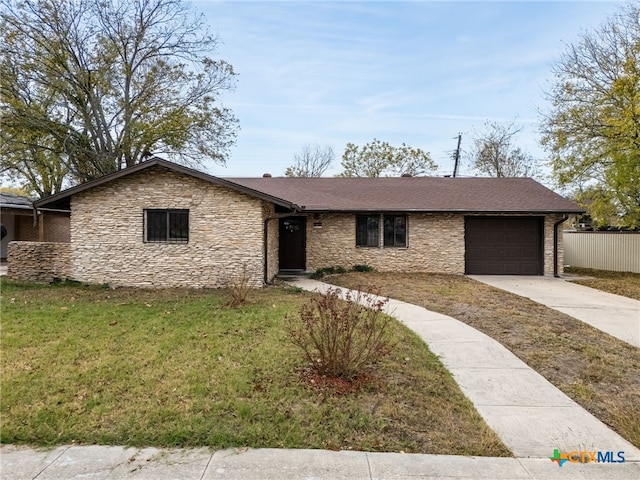 ranch-style house featuring a front lawn and a garage