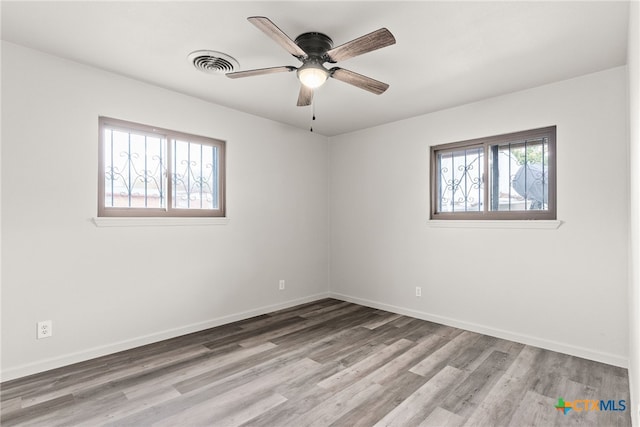 spare room with ceiling fan, a healthy amount of sunlight, and light wood-type flooring