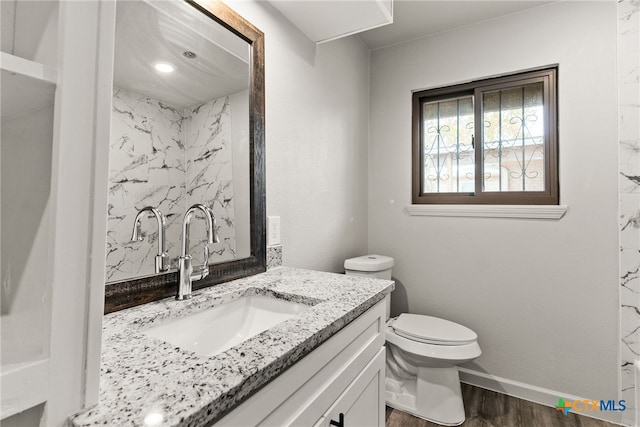 bathroom with hardwood / wood-style flooring, vanity, and toilet