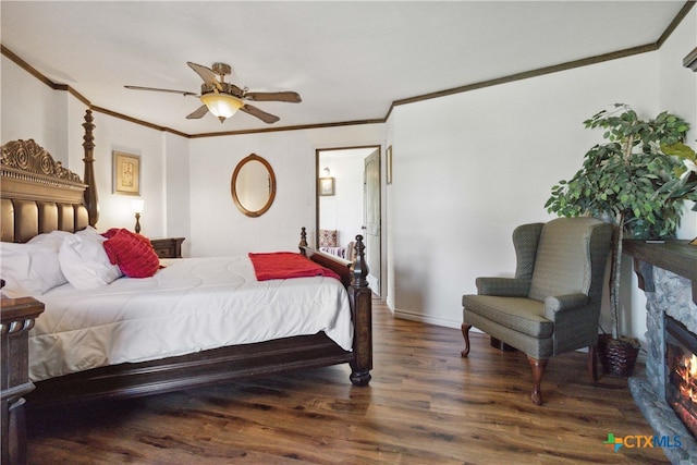 bedroom featuring ceiling fan, crown molding, a stone fireplace, and dark hardwood / wood-style flooring