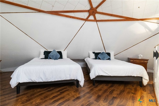 bedroom featuring vaulted ceiling and dark hardwood / wood-style flooring