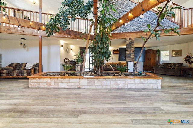 interior space featuring a fireplace, a high ceiling, and wood-type flooring