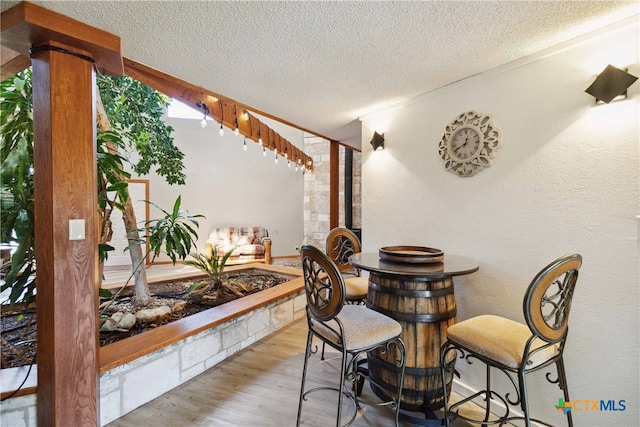 dining room featuring light hardwood / wood-style flooring and a textured ceiling