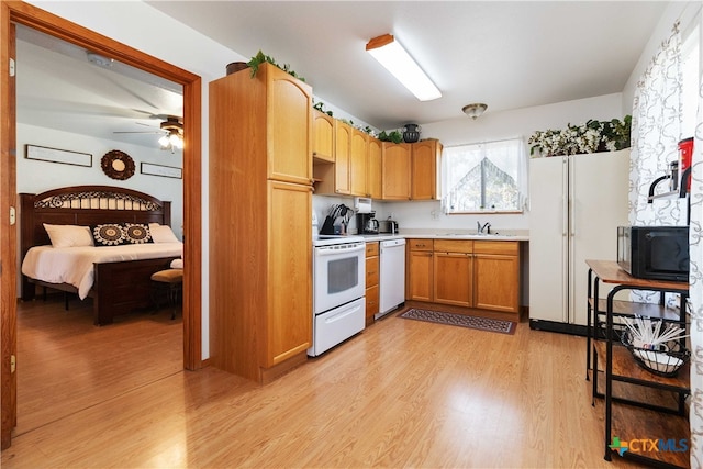 kitchen with white appliances, ceiling fan, sink, and light hardwood / wood-style flooring