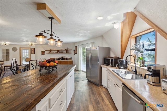 kitchen with butcher block counters, white cabinetry, appliances with stainless steel finishes, sink, and dark wood-type flooring