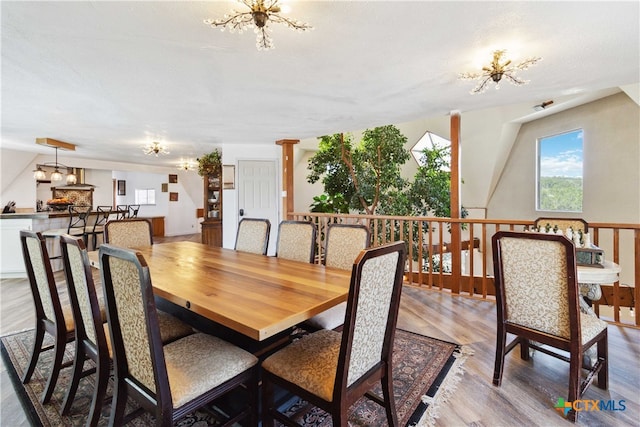 dining area featuring a textured ceiling, a notable chandelier, and light hardwood / wood-style flooring