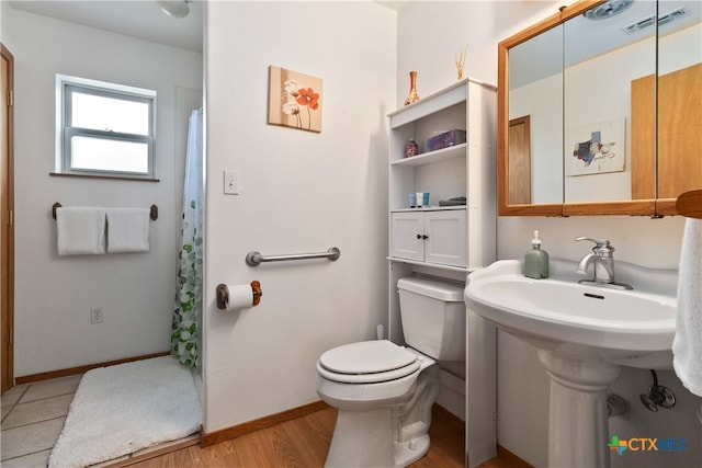 bathroom featuring hardwood / wood-style floors and toilet