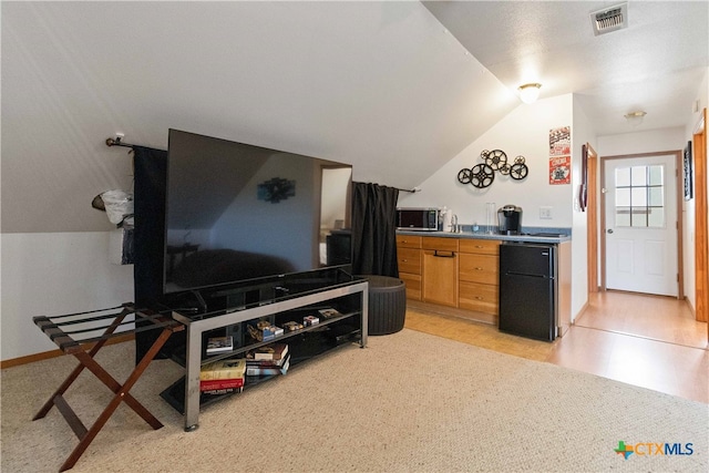 kitchen featuring black refrigerator and lofted ceiling