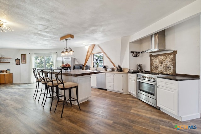 kitchen with stainless steel appliances, kitchen peninsula, hanging light fixtures, a breakfast bar area, and white cabinetry