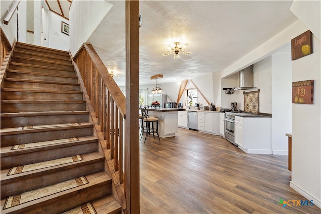 staircase with hardwood / wood-style floors and a textured ceiling