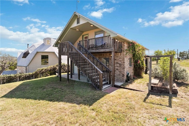 back of house with a lawn, a patio, and a deck