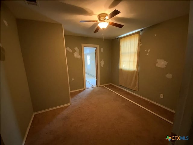 carpeted spare room featuring ceiling fan