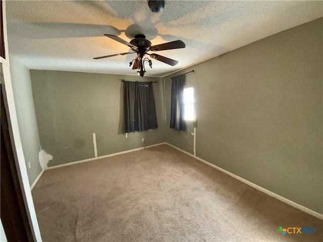 carpeted spare room with ceiling fan and a textured ceiling