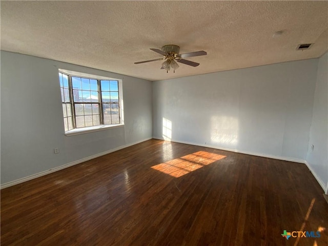 empty room featuring a textured ceiling, dark hardwood / wood-style floors, and ceiling fan