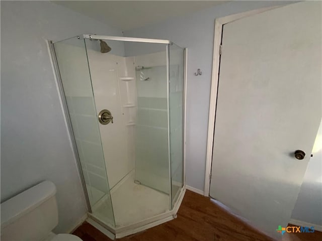 bathroom with a shower with door, wood-type flooring, and toilet