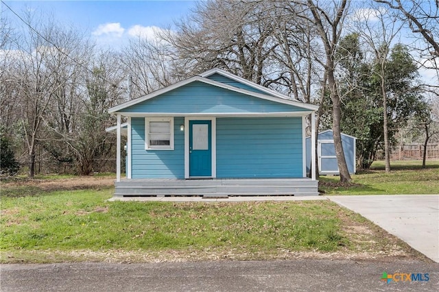 bungalow-style house with a garage, an outbuilding, and a front yard