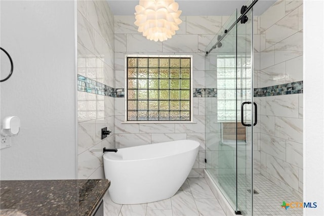 5705 Fenton Ln, Belton, TX 76513 - bathroom featuring a soaking tub, healthy amount of natural light, marble finish flooring, a stall shower, and tile walls