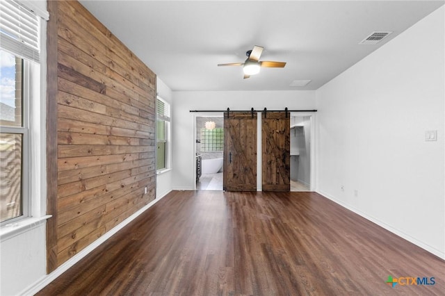 5705 Fenton Ln, Belton, TX 76513 - empty room featuring wood finished floors, a ceiling fan, a barn door, and baseboards
