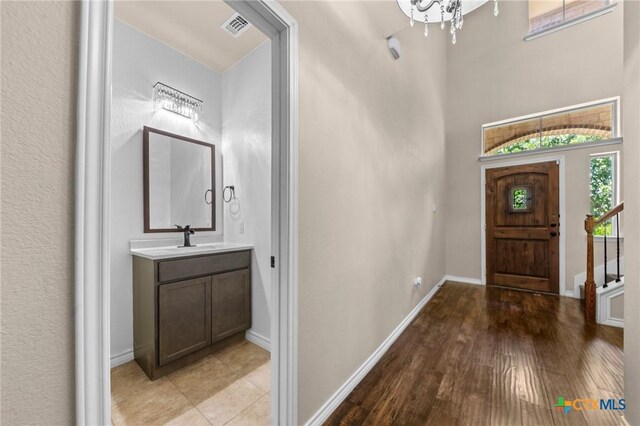 5705 Fenton Ln, Belton, TX 76513 - entrance foyer with baseboards, light wood-style flooring, a high ceiling, and a chandelier