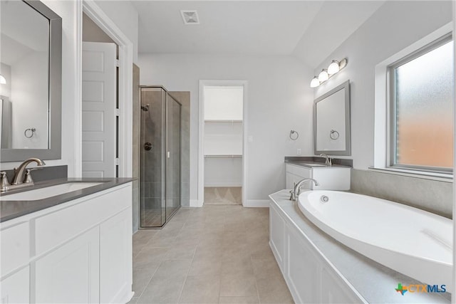 bathroom featuring vaulted ceiling, tile patterned flooring, shower with separate bathtub, and vanity