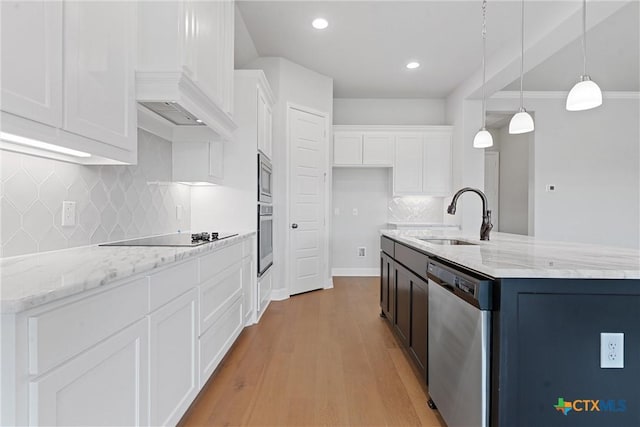 kitchen featuring pendant lighting, sink, white cabinetry, an island with sink, and stainless steel appliances