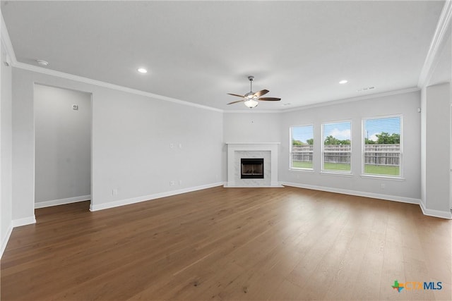 unfurnished living room featuring ceiling fan, dark hardwood / wood-style floors, a premium fireplace, and crown molding