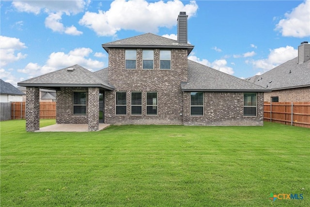 back of house featuring a lawn and a patio