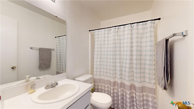 bathroom with walk in shower, vanity, and toilet