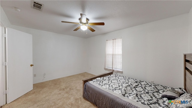 carpeted bedroom featuring ceiling fan and a textured ceiling