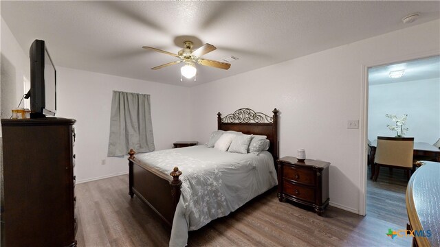 bedroom featuring wood-type flooring, ceiling fan, and a textured ceiling