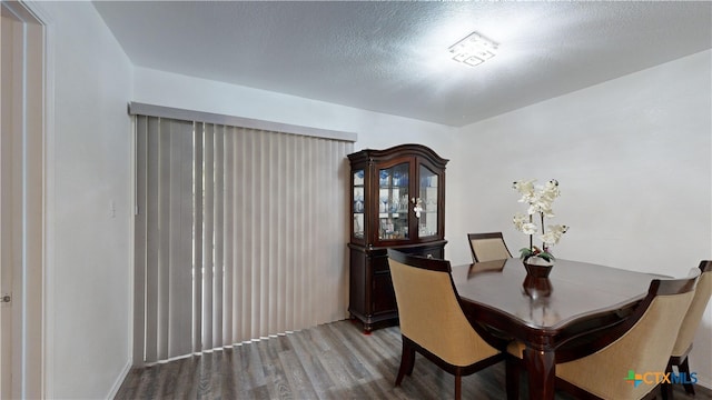 dining room with a textured ceiling and hardwood / wood-style flooring