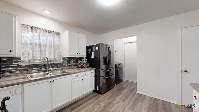 kitchen with stainless steel refrigerator with ice dispenser, sink, light hardwood / wood-style floors, and white cabinets