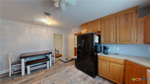 kitchen with black fridge with ice dispenser, light hardwood / wood-style floors, and ceiling fan