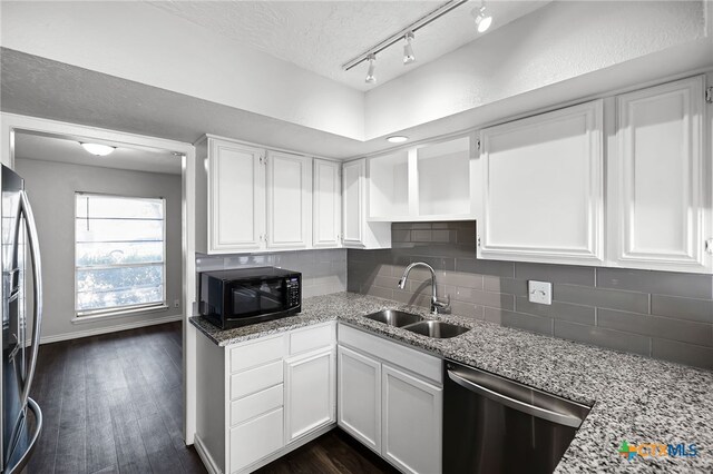 kitchen with appliances with stainless steel finishes, tasteful backsplash, white cabinetry, dark wood-type flooring, and a textured ceiling