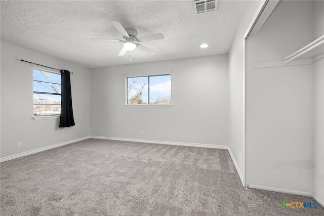 spare room with carpet floors, a textured ceiling, and ceiling fan