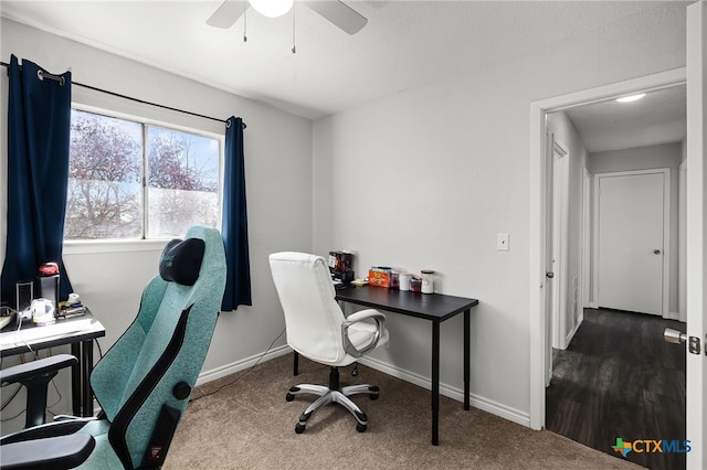 carpeted home office featuring ceiling fan