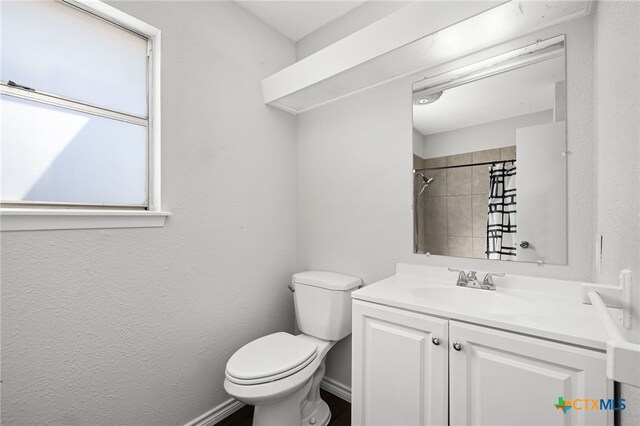 bathroom featuring vanity, toilet, and a tile shower