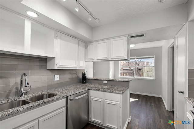 kitchen featuring sink, white cabinets, backsplash, stainless steel dishwasher, and kitchen peninsula