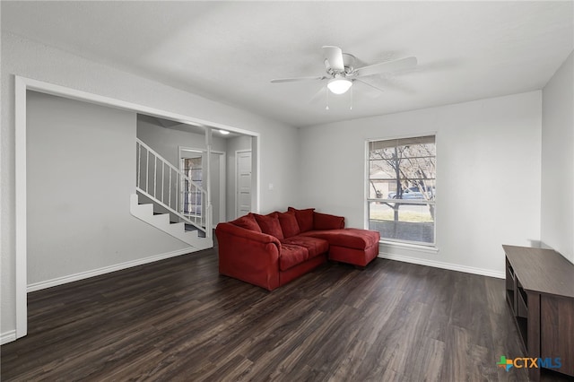 living room featuring dark wood-type flooring and ceiling fan