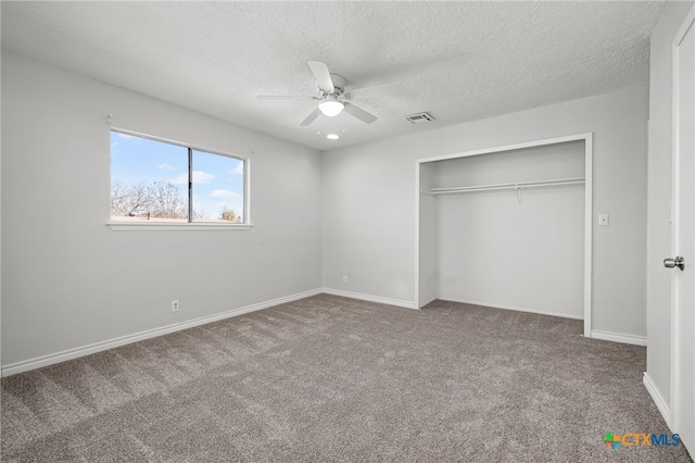 unfurnished bedroom featuring ceiling fan, carpet floors, a textured ceiling, and a closet