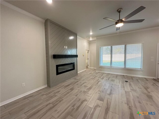 kitchen with ceiling fan, sink, hanging light fixtures, an island with sink, and a fireplace