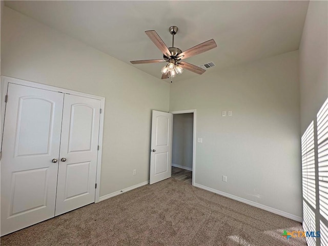 unfurnished bedroom with dark carpet and ceiling fan