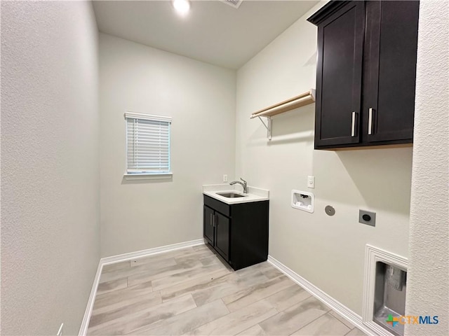 laundry area with cabinets, sink, hookup for a washing machine, light hardwood / wood-style flooring, and hookup for an electric dryer