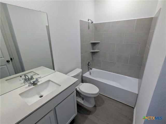 bathroom with vanity, wood finished floors, shower / washtub combination, toilet, and a textured wall