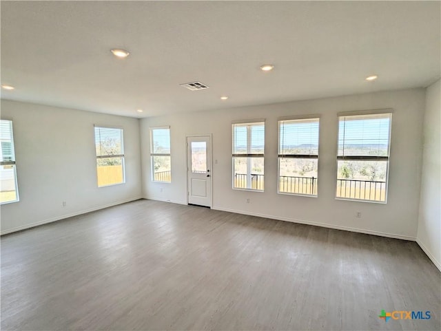 empty room featuring dark wood-type flooring, recessed lighting, visible vents, and baseboards