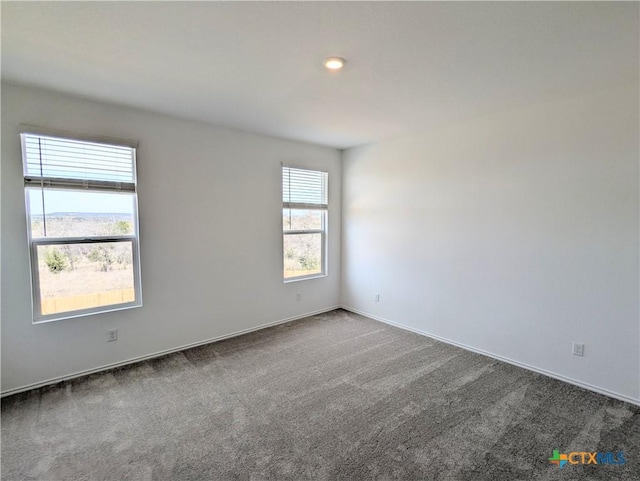 carpeted empty room featuring baseboards