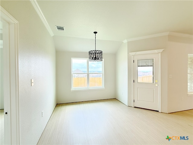 unfurnished dining area featuring crown molding, light wood-type flooring, a chandelier, and visible vents