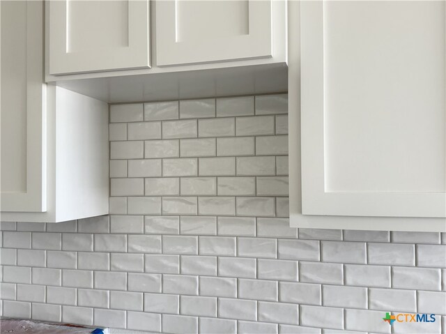 room details featuring white cabinetry and tasteful backsplash
