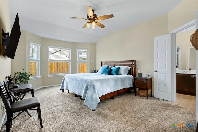 bedroom featuring a ceiling fan, light colored carpet, vaulted ceiling, and baseboards